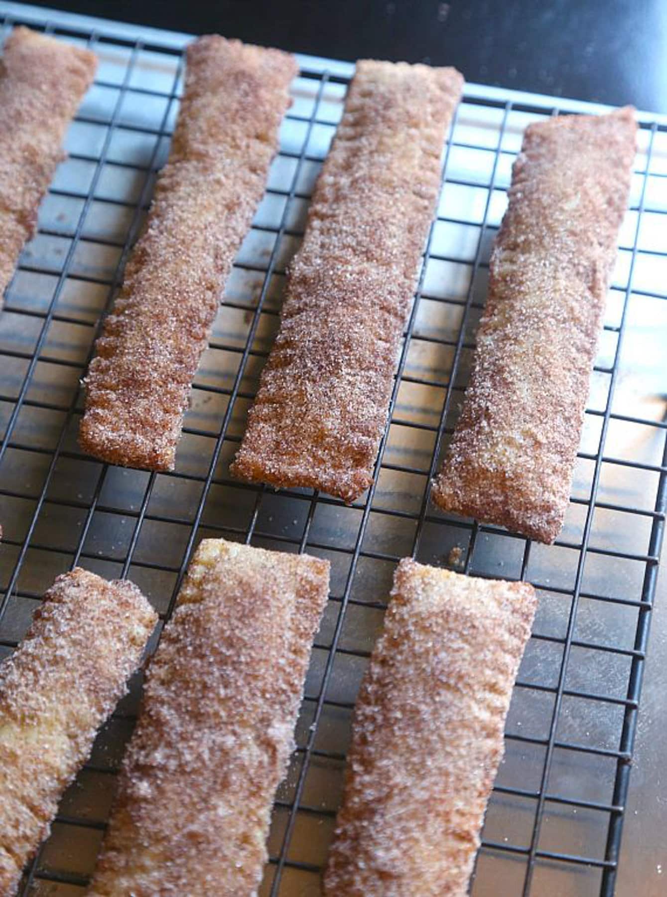 Churro sticks laid out on to a cooling rack