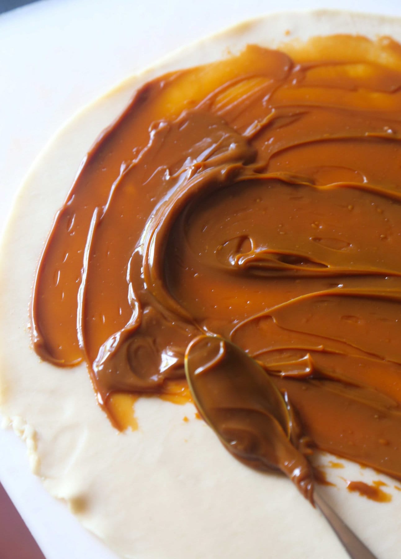 Dolce de Leche sauce spread onto a pie crust