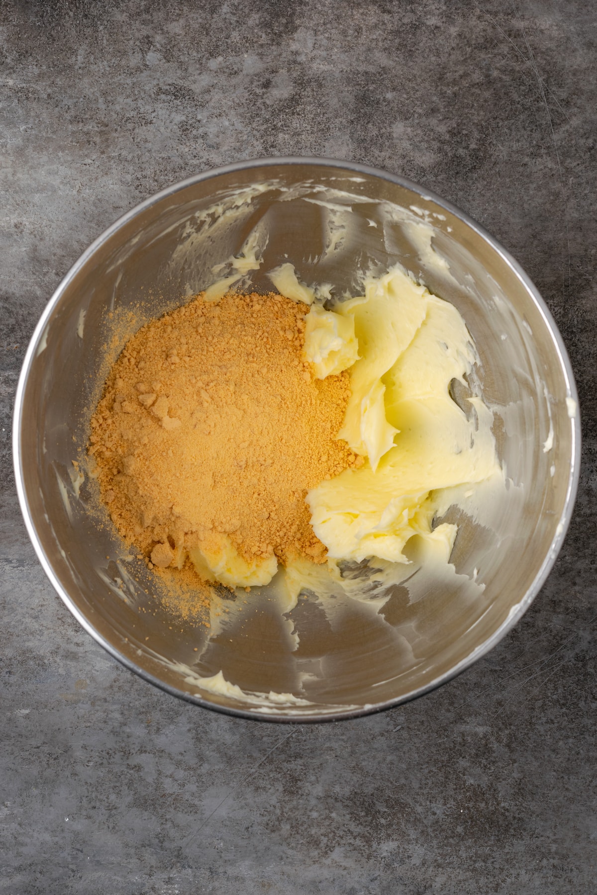 Butterscotch chips added to a metal mixing bowl with creamed butter and sugar.