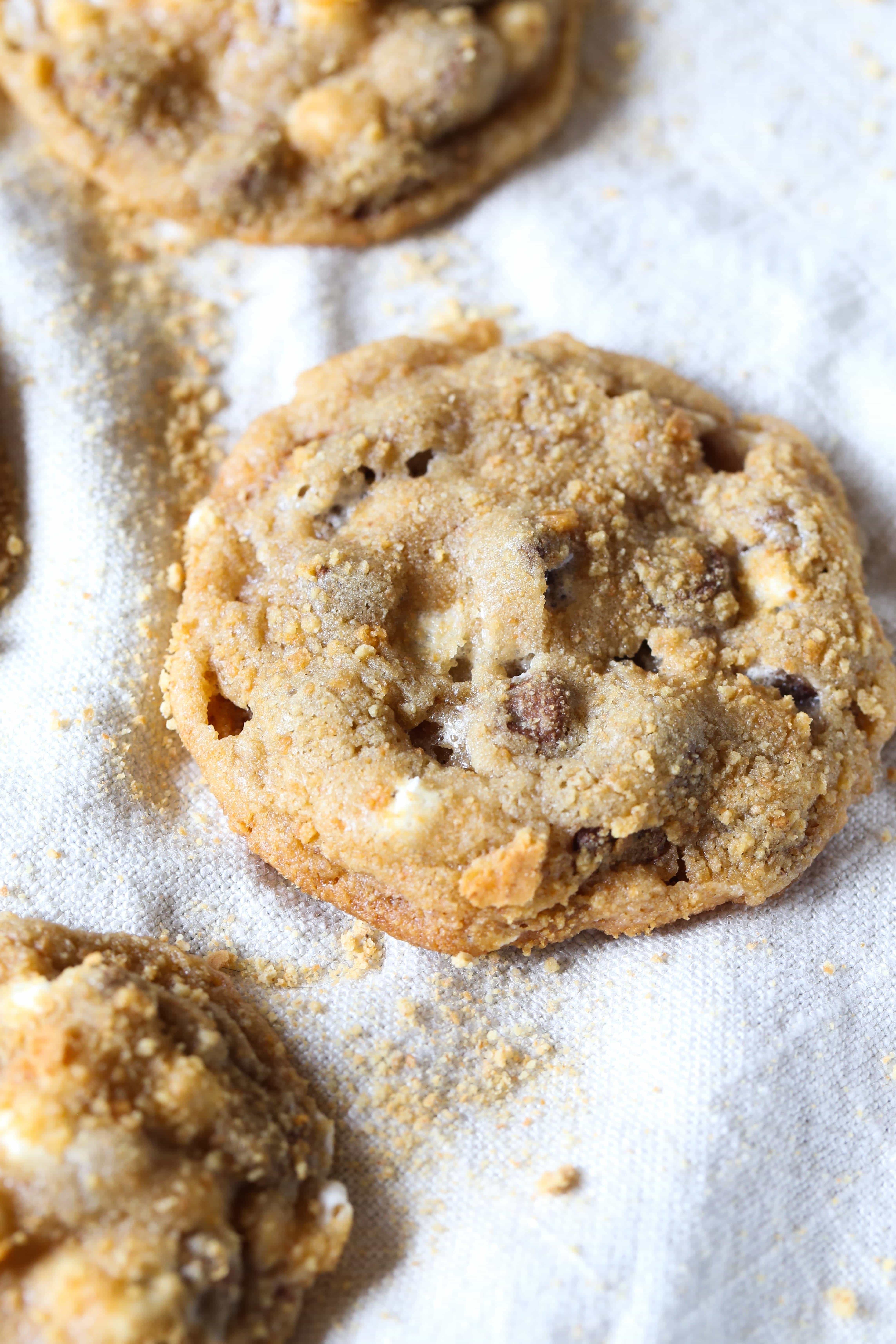 These easy s’more chocolate chip cookies are filled with melty chocolate and mini marshmallows and covered in graham cracker crumb "dirt"! Chewy s'more chocolate chip cookies covered in graham cracker crumbs.