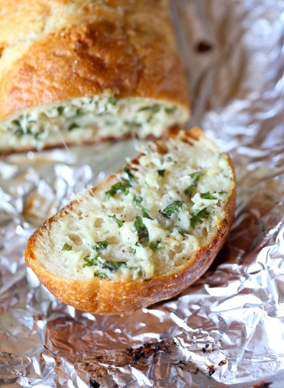 A slice of homemade garlic bread on foil