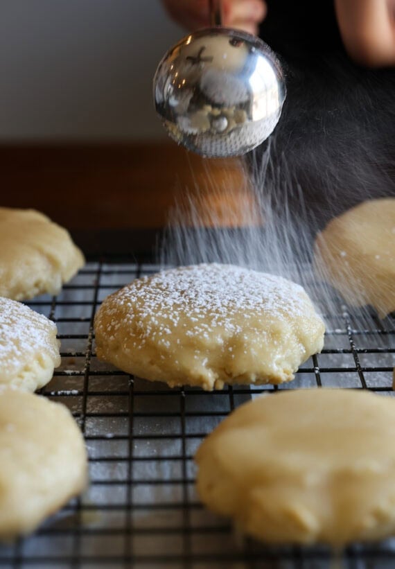 Dusting a butter cookie with powdered sugar