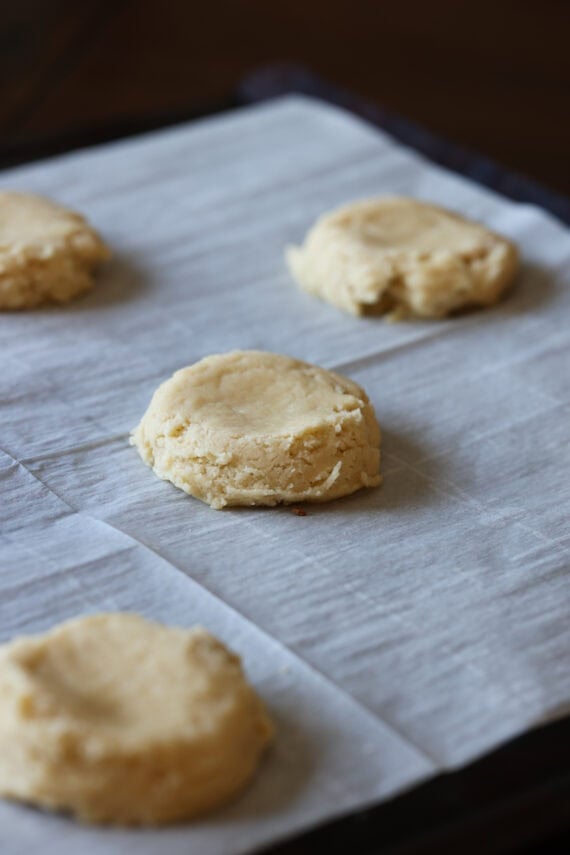 pressed cookies on a baking sheet with parchment paper