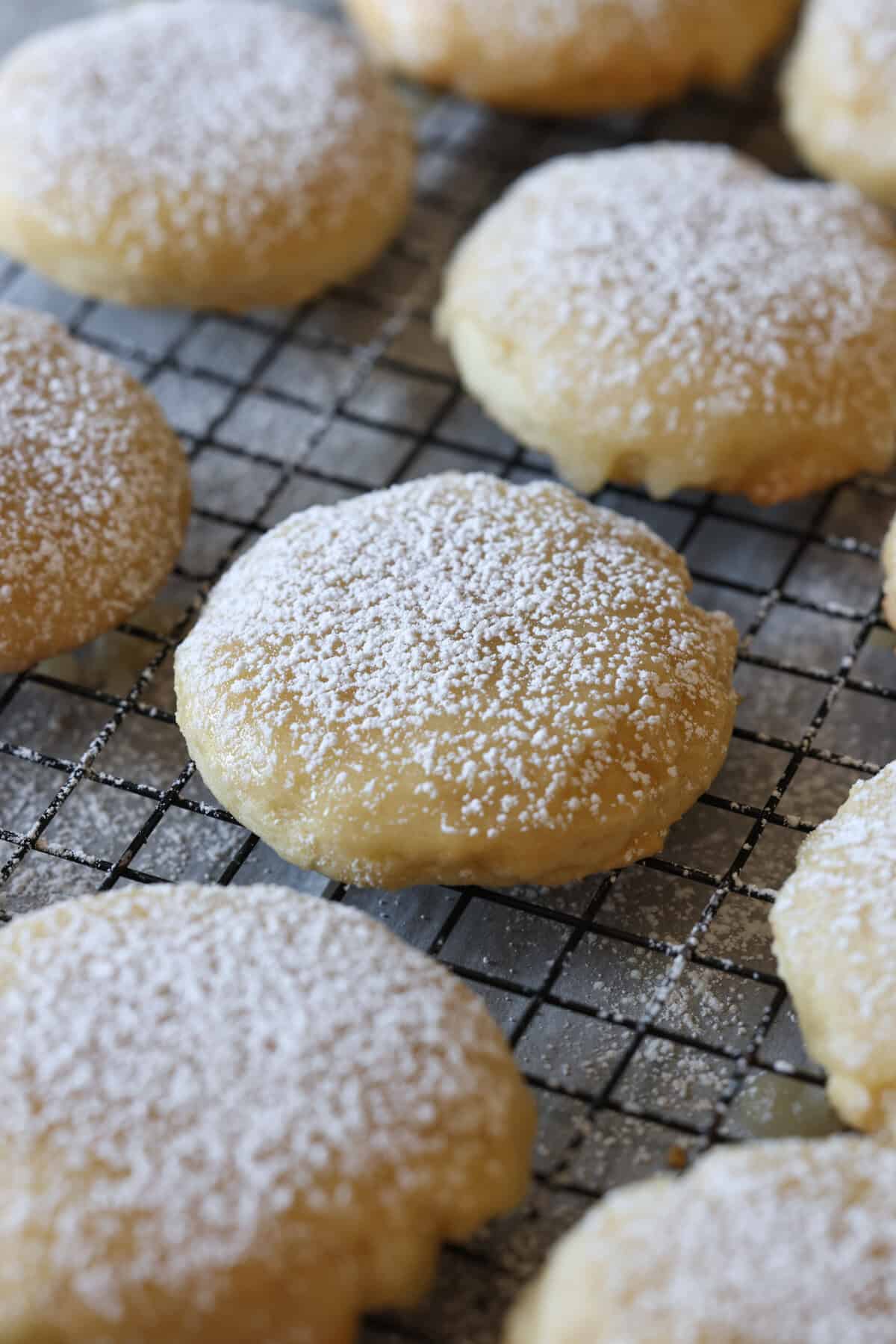 A Kentucky Butter Cake Cookie dusted with powdered sugar on a cooling rack