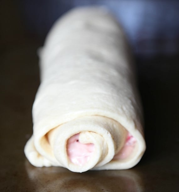 Quick and easy strawberry cinnamon rolls are soft, gooey, and loaded with fresh strawberries rolled inside refrigerated crescent roll dough. Crescent roll dough rolled up in a log with strawberry cream cheese filling.