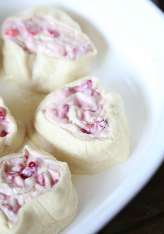 Quick and easy strawberry cinnamon rolls are soft, gooey, and loaded with fresh strawberries rolled inside refrigerated crescent roll dough. Unbaked strawberry cinnamon rolls in a baking dish.