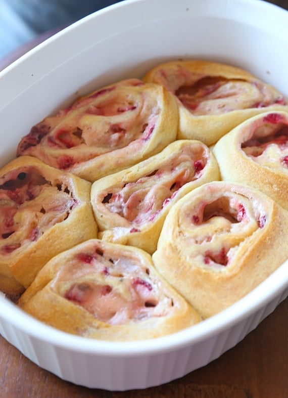 Quick and easy strawberry cinnamon rolls are soft, gooey, and loaded with fresh strawberries rolled inside refrigerated crescent roll dough. Golden-baked strawberry cinnamon rolls in a baking dish.