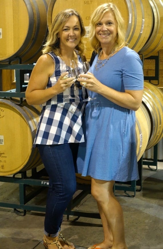 Christie and Shelly holding glasses of Chardonnay and smiling at Fess Parker winery