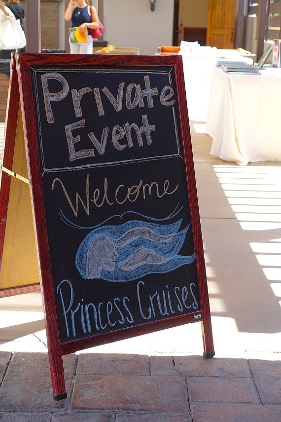 An outdoor chalkboard sign reading "private event, welcome Princess Cruises"