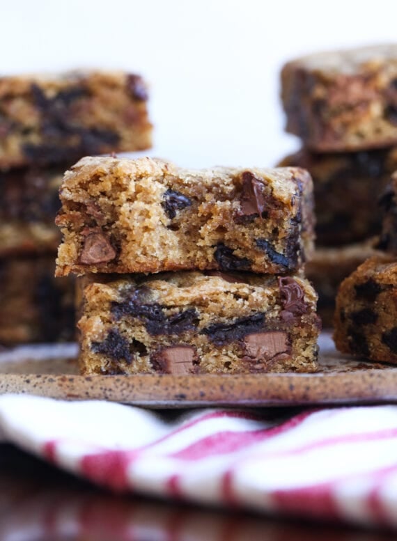 Two stacked chocolate chip cookie bars with a bite taken out
