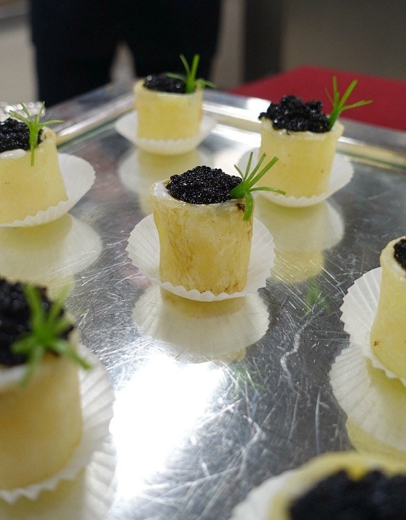 Small appetizer bites on a metal tray with cupcake liners beneath each one