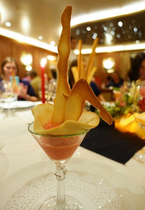 Wafer-thin cookies sticking out of a glass filled with blended fruits