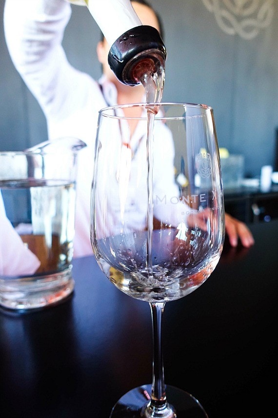 White wine being boured into a glass labeled Monte Xanic