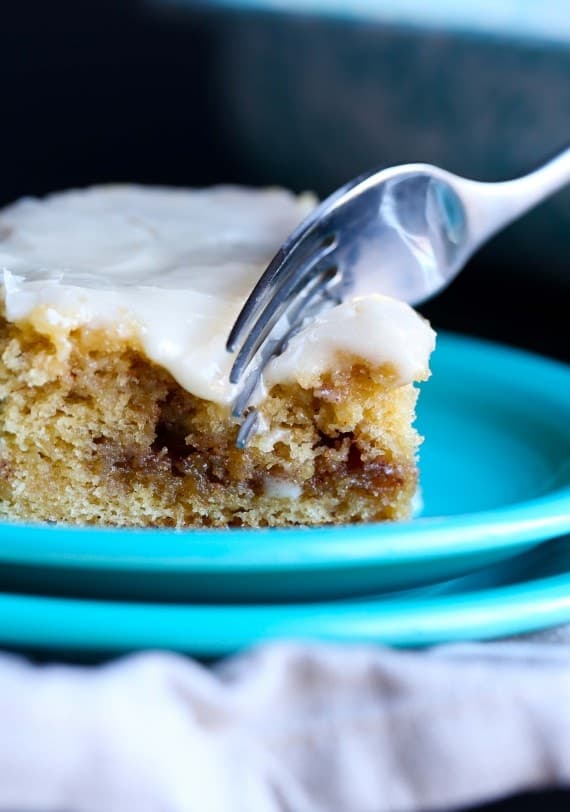 Close-up of a slice of honeybun cake on a plate with a fork