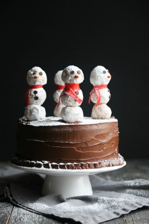 This gorgeous Snowman Cake is as simple to make as it is stunning! Donut Holes create adorable snowmen on sticks simply placed in the top of a chocolate cake!
