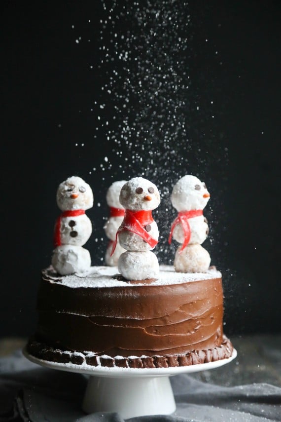 This gorgeous Snowman Cake is as simple to make as it is stunning! Donut Holes create adorable snowmen on sticks simply placed in the top of a chocolate cake!