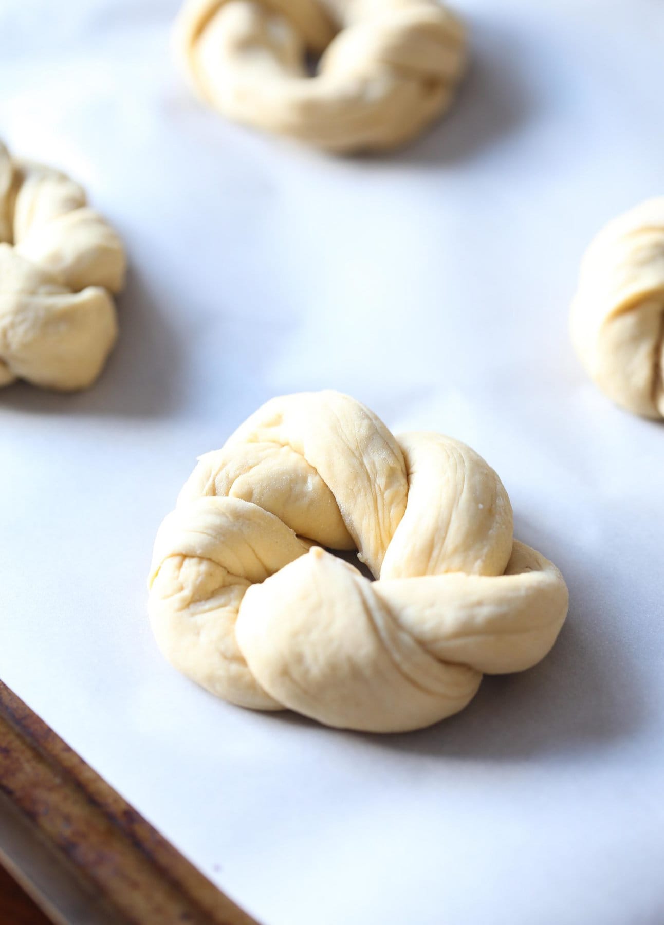 Formed garlic knot on a sheet ready to bake