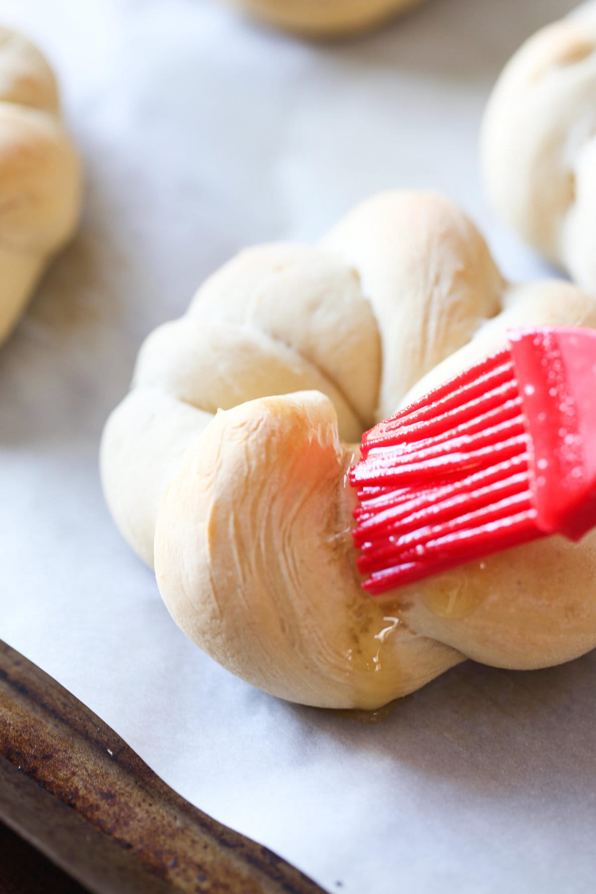 Butter being spread onto a garlic knot