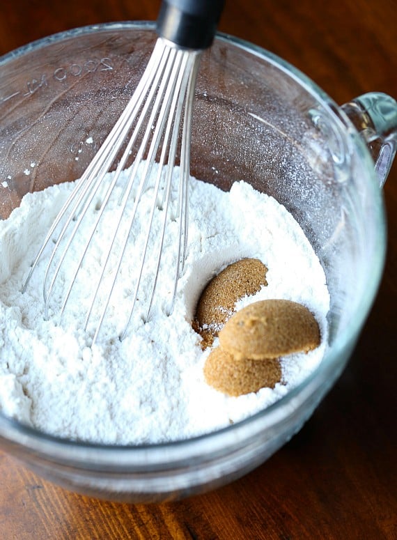 A bowl with flour,brown sugar and a whisk.