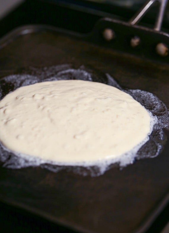 Pancake batter cooking on the griddle.