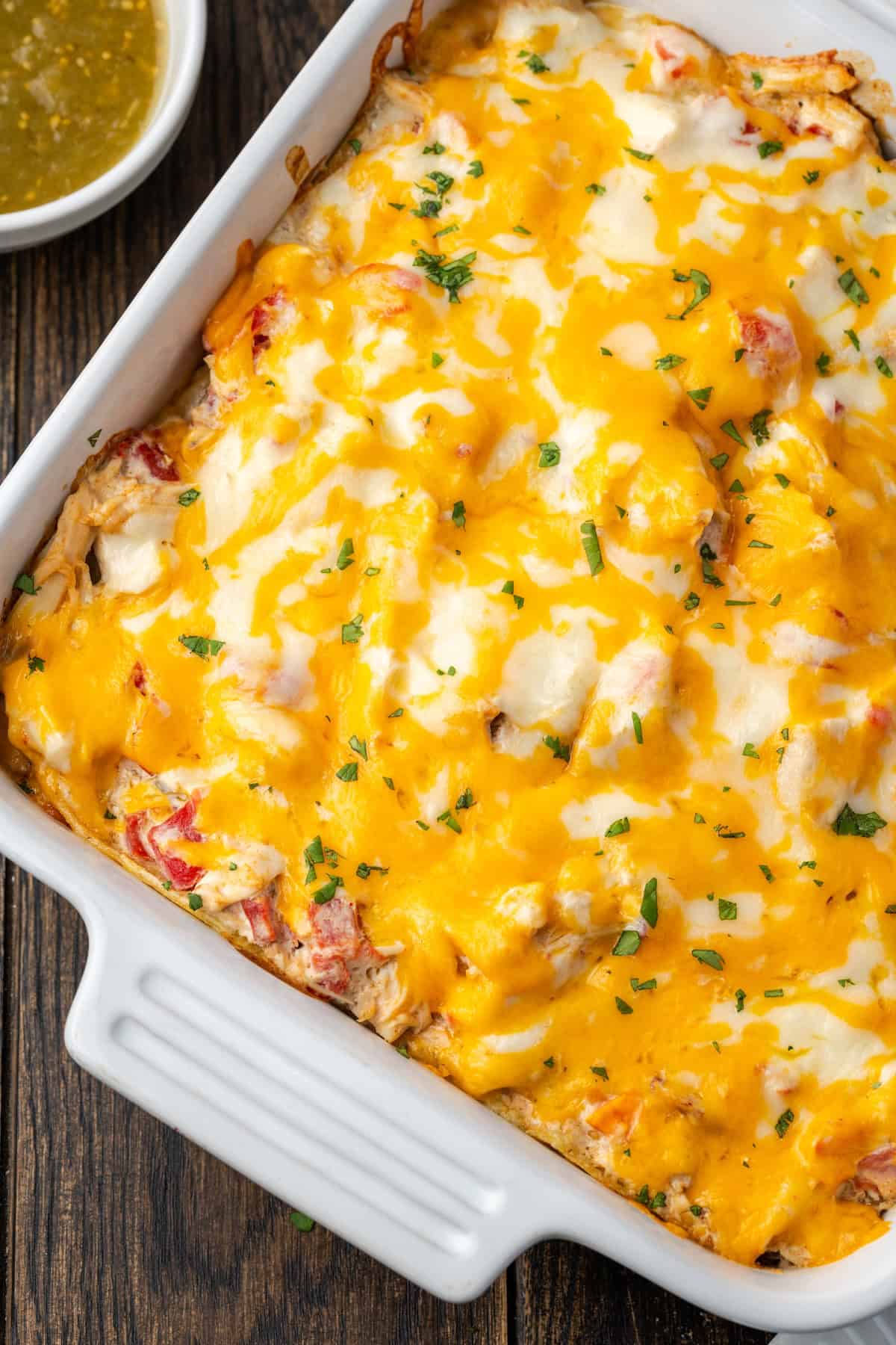 Overhead view of baked salsa verde chicken casserole in a ceramic casserole dish.