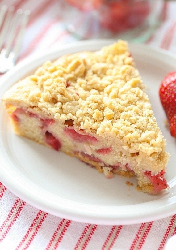 A slice of strawberry buckle on a white plate.