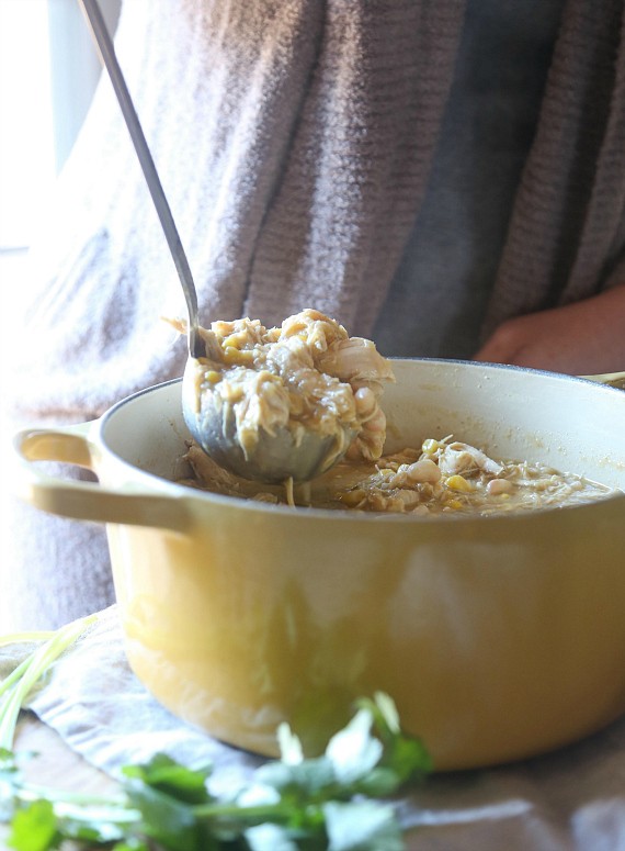 White chicken chili is ladled out of a Dutch oven.