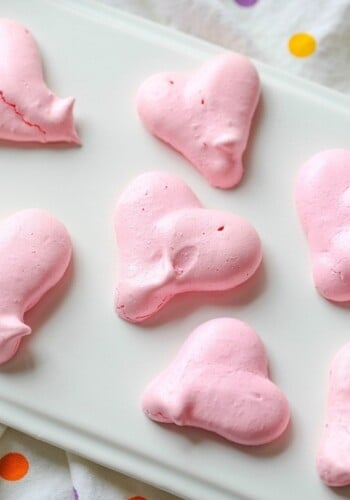Heart Shaped Meringue Cookies on white parchment paper.