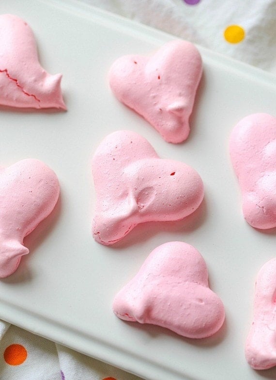 Heart Shaped Meringue Cookies on white parchment paper.