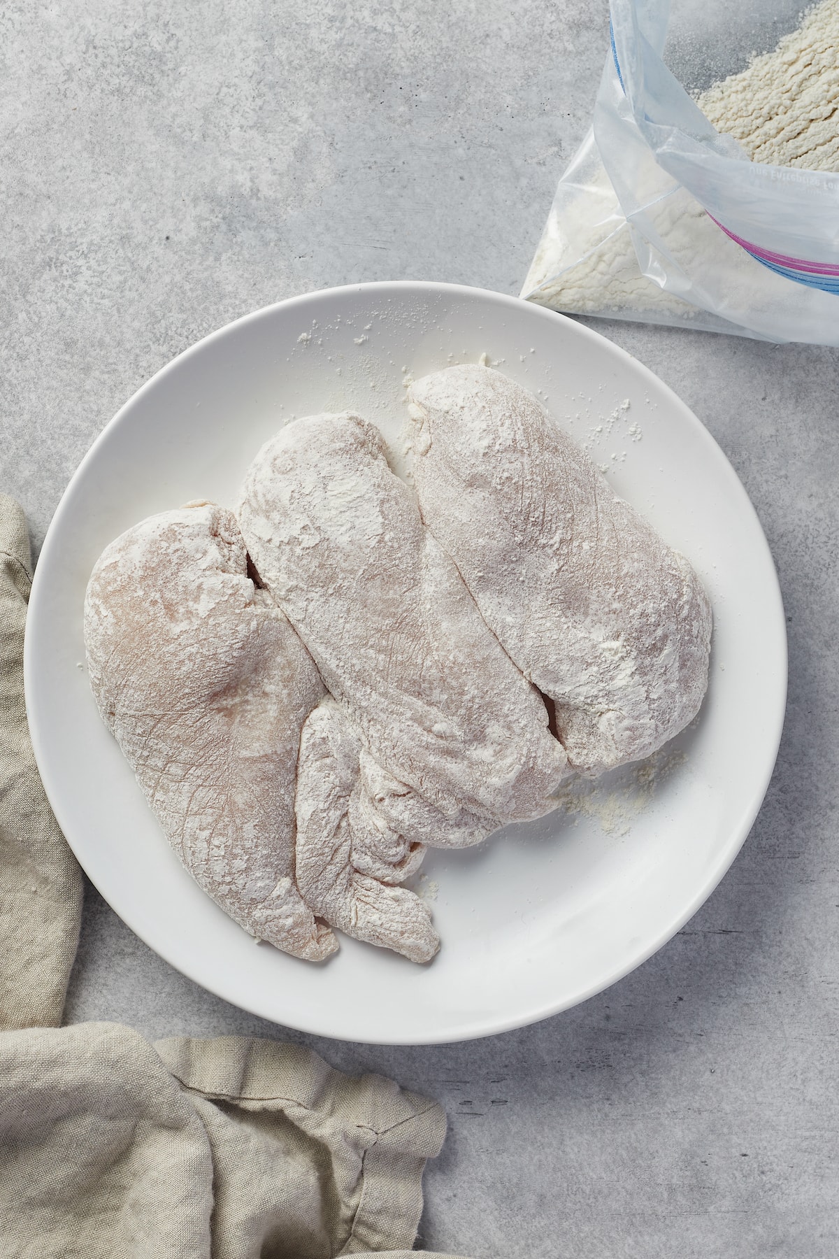 Chicken breasts coated with flour.