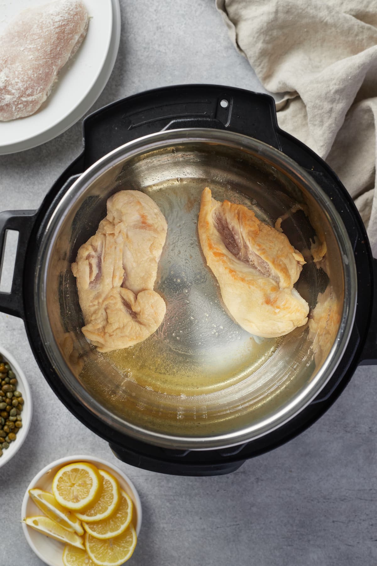 Chicken breasts are browned in the bowl of an Instant Pot.
