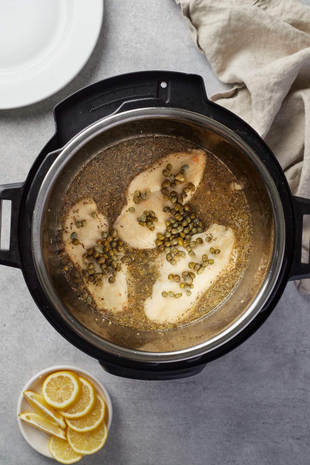 Chicken breasts and lemon sauce ingredients are combined in the Instant Pot.