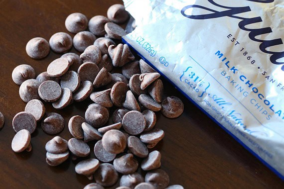 Guittard Milk Chocolate Chips spill out of an unsealed bag.