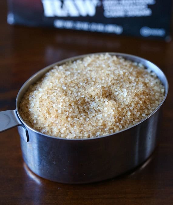 Raw Turbinado sugar in a metal measuring cup.