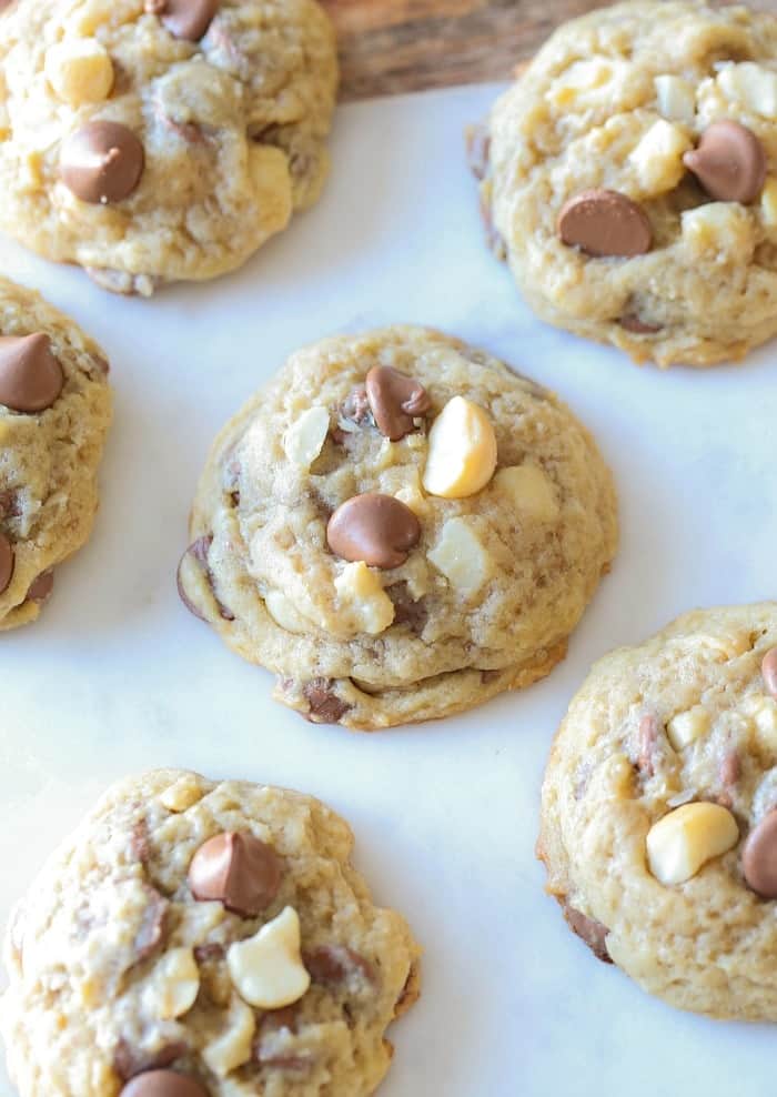 Homemade Sausalito cookies with chocolate chips and macadamia nuts on white parchment paper.