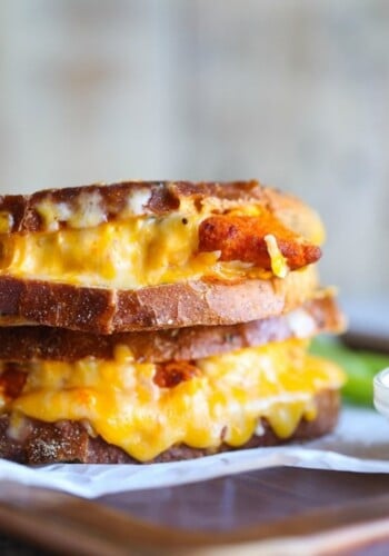 Melted cheese dripping out of a Buffalo Chicken Grilled Cheese sandwich stacked on each other.