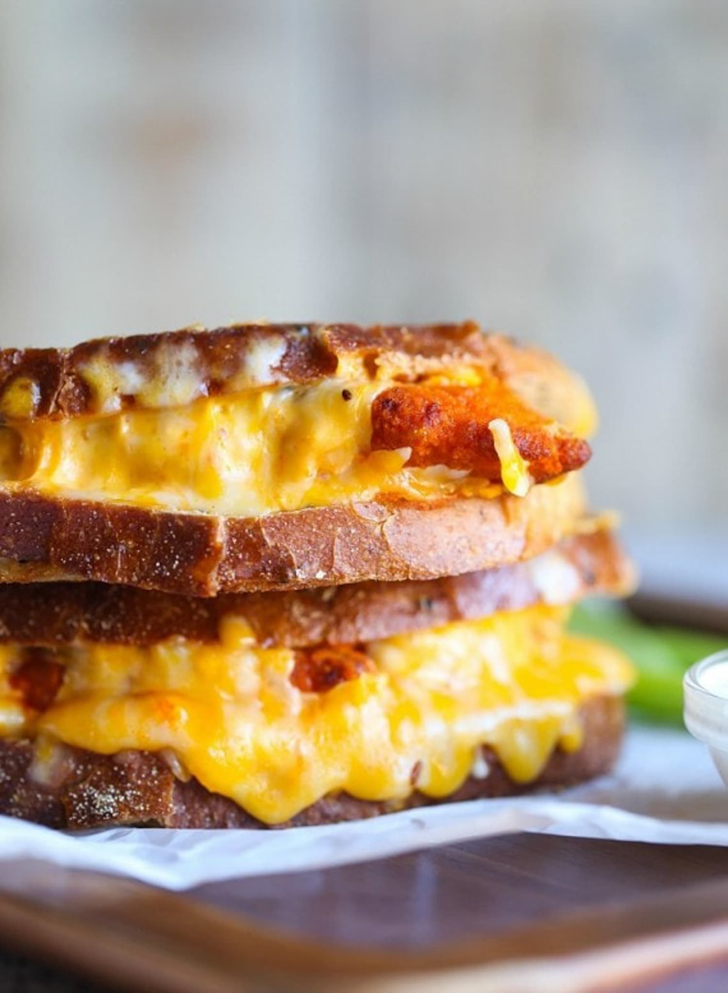 Melted cheese dripping out of a Buffalo Chicken Grilled Cheese sandwich stacked on each other. 
