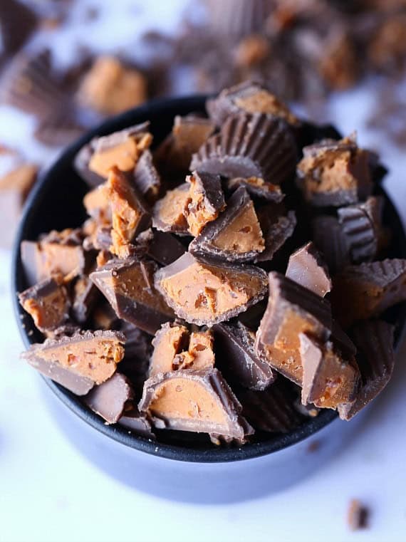 A bowl full of chopped up Butterfinger peanut butter cups.
