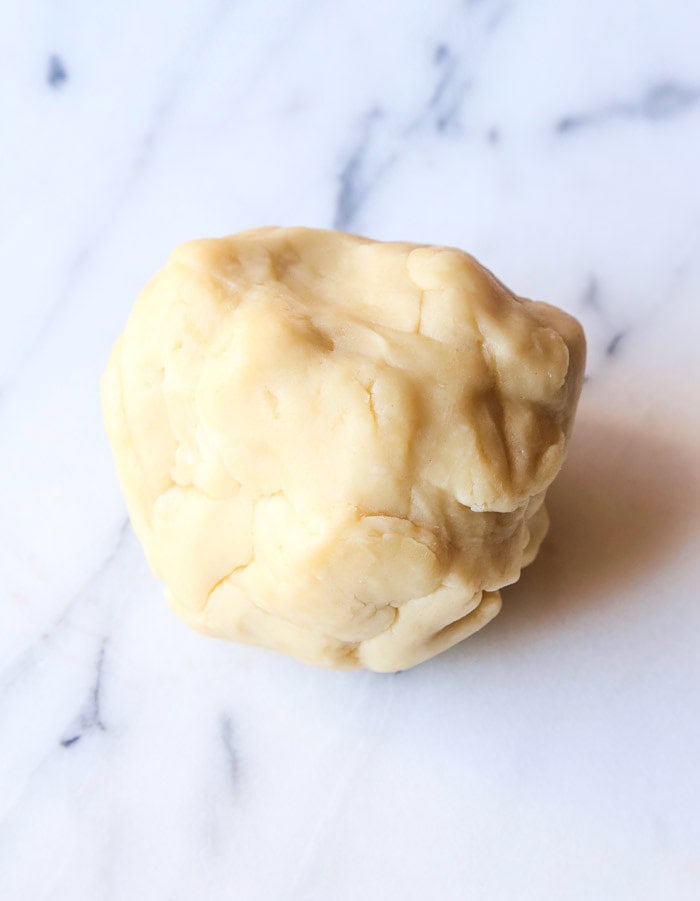 A Ball of Cream Cheese Pie Crust Dough on a Marble Surface