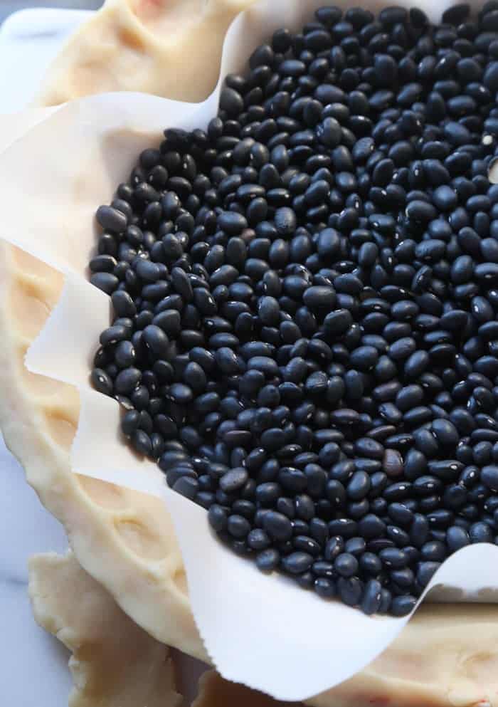 Dried Beans Weighing Down a Pie Crust with a Layer of Parchment Paper in Between