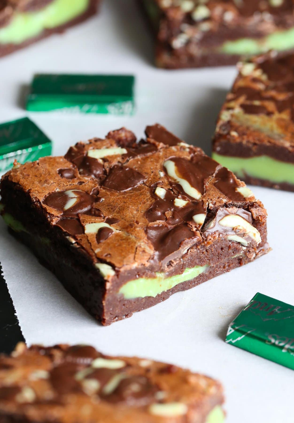 An assortment of mint fudge stuffed brownies surrounded by mint chocolate candies.