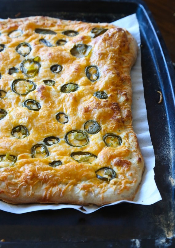 A Jalapeno Popper Pizza on a Pan Lined with Parchment Paper