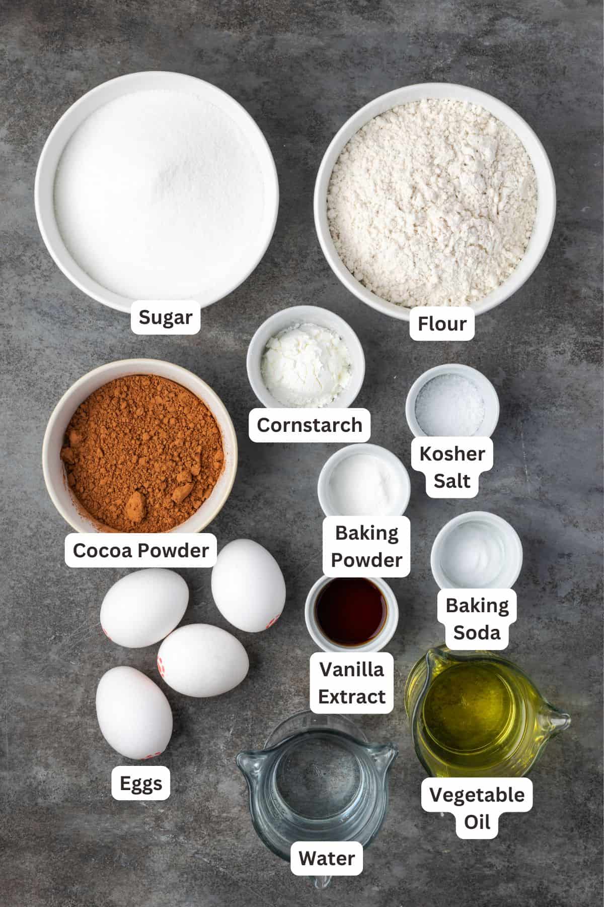 Ingredients for frosted fudge cake with text labels overlaying each ingredient.