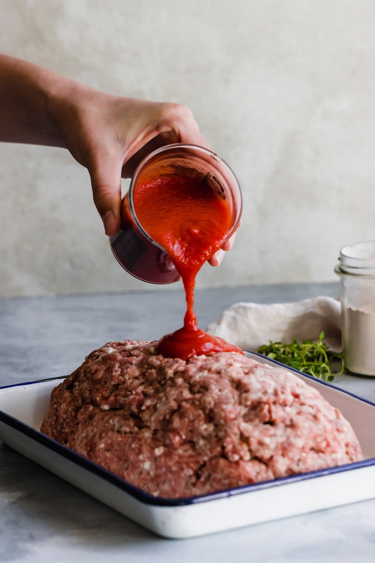 Meatloaf with sauce being poured on top of it.