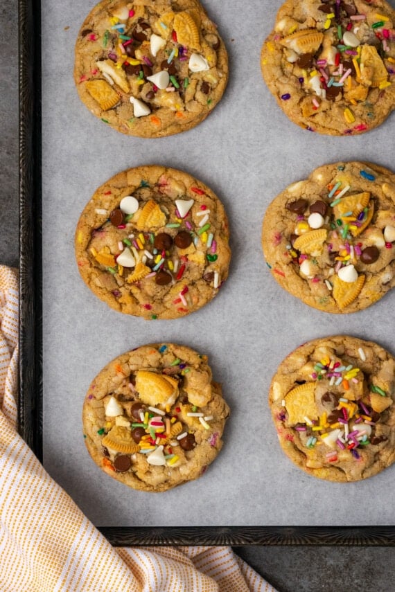 Celebrate with soft and chewy birthday cake cookies loaded up with vanilla cake batter, chocolate chips, Golden Oreos, and rainbow sprinkles! Baked birthday cake cookies on a lined baking sheet.