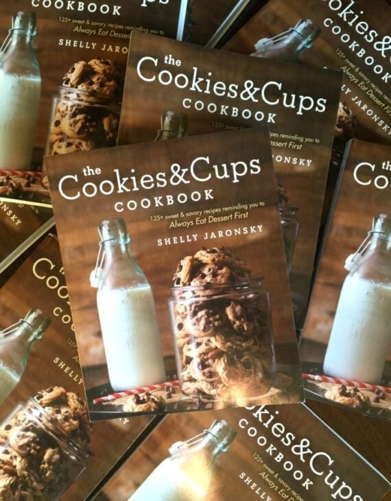A Pile of Cookies & Cups Cookbooks on a Wooden Table