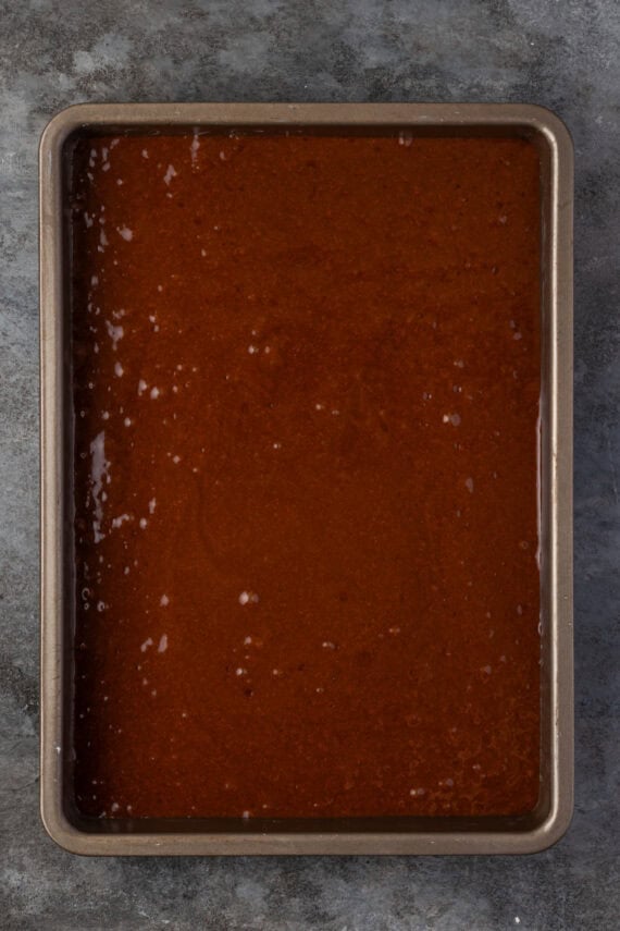 Chocolate cake batter in a large baking pan.