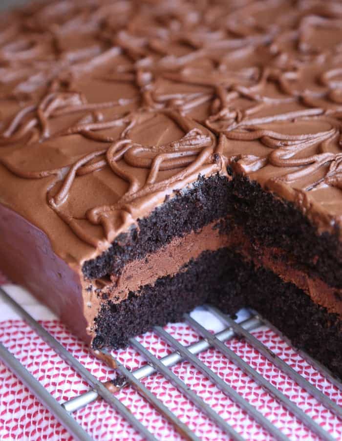 Frosted fudge cake with a slice missing to show the layers.