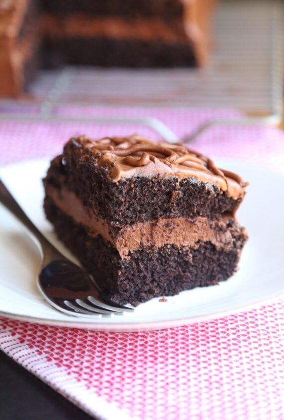 A slice of frosted fudge cake on a plate.