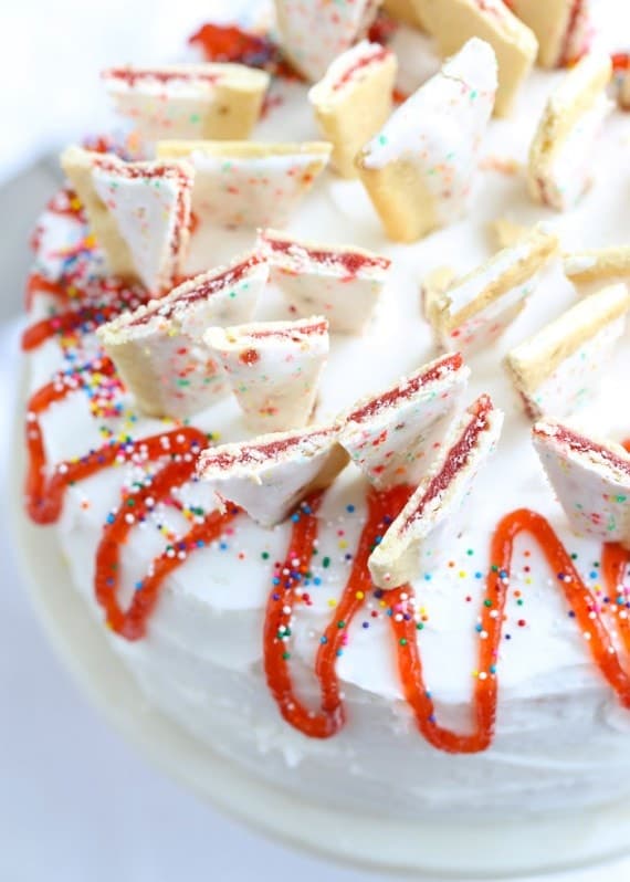 Strawberry Pop Tart Cake....a soft vanilla cake topped with buttercream, chopped Pop Tarts, strawberry jam and sprinkles! SUPER CUTE!